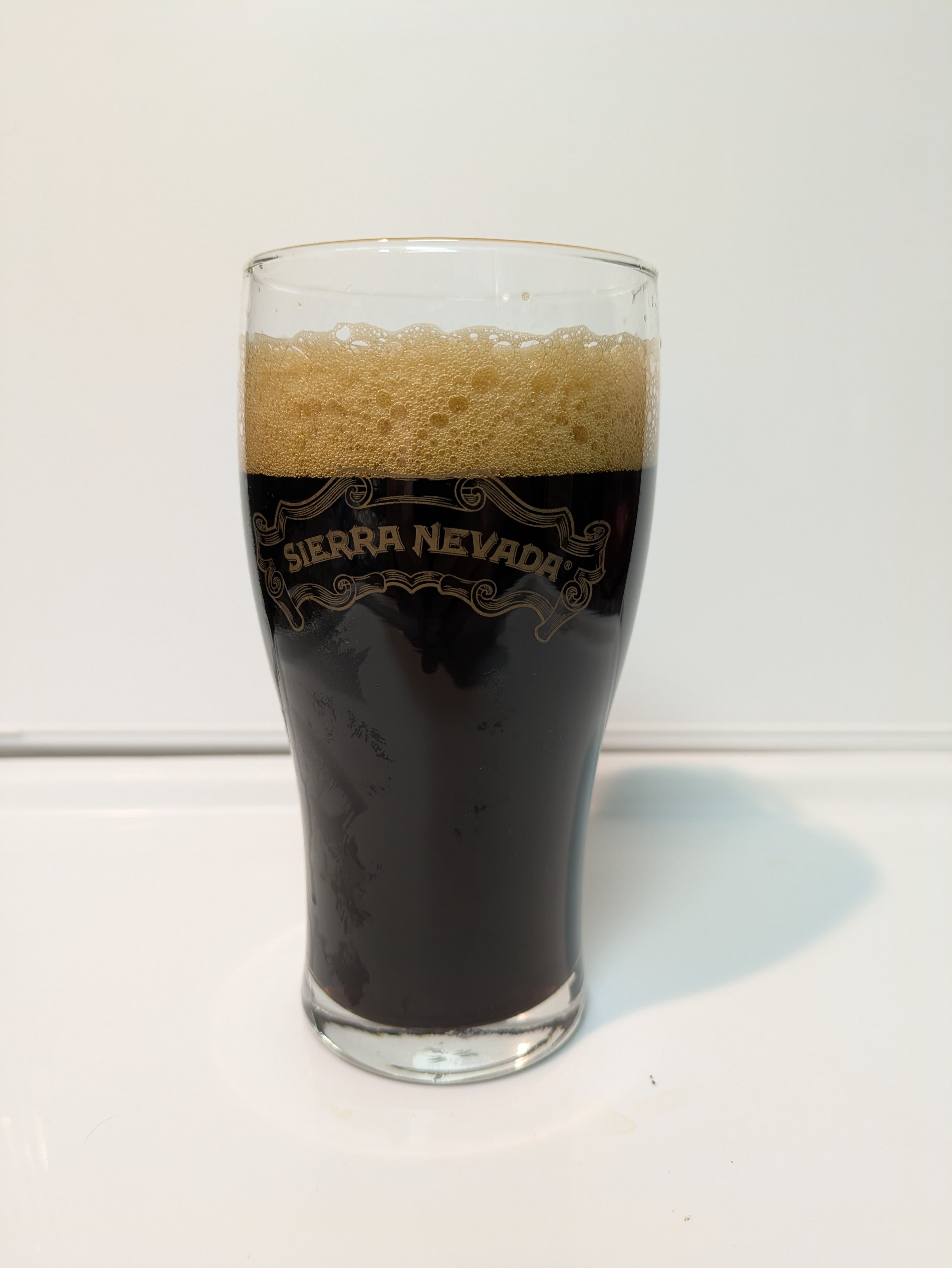 Opaque black beer with tan head in a glass that says Sierra Nevada 